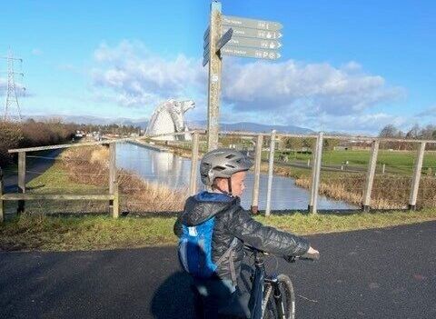 Boy with bicycle with kelpies 